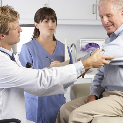 Doctor Examining Male Patient With Elbow Pain