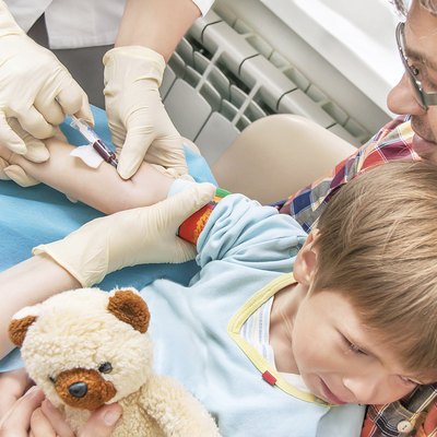 Collecting a blood from a vein from the kid.