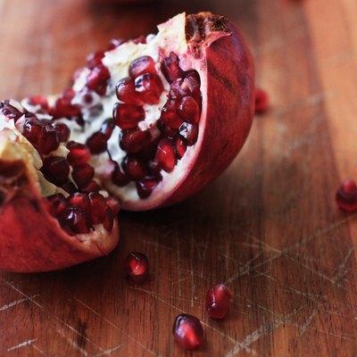 Freshly split pomegranate on a wooden chopping board
