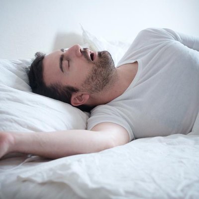 Man sleeping in his bed and snoring loudly