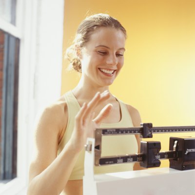 Woman weighing herself, adjusting scales