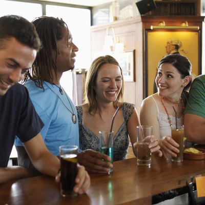 Group of friends standing at bar, smiling