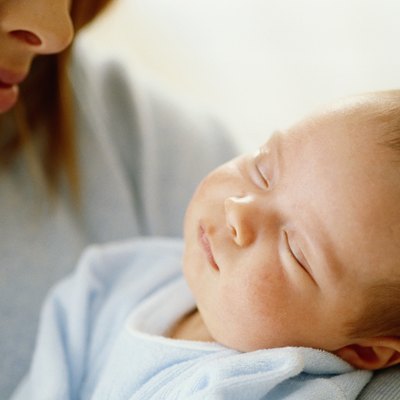 Woman looking down at baby sleeping