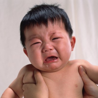 Baby boy is lifted, crying, portrait, front view