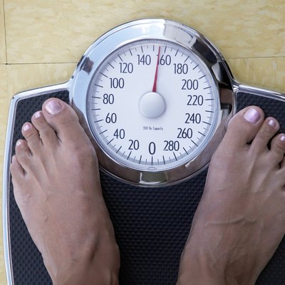 Low section view of a woman standing on a weighing scale