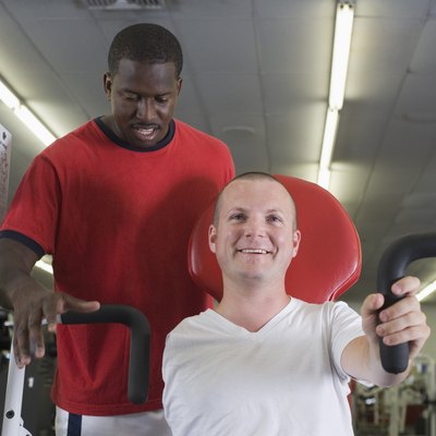 One-armed man in gym with trainer