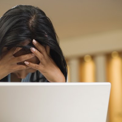 Woman stressed out in front of laptop computer