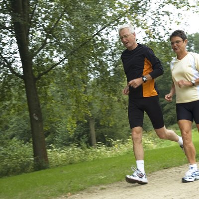 Senior Couple Running In The Woods
