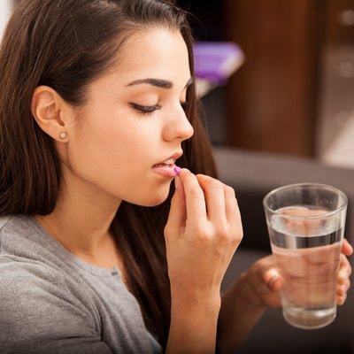 Young woman taking a pill