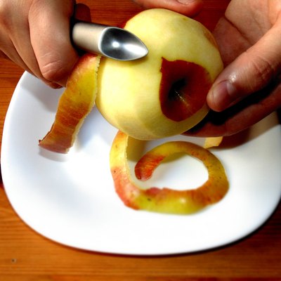 Hands peeling apple