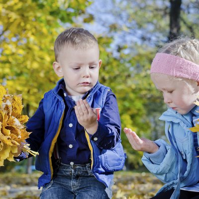 Boy and Girl Holding Autumn Leaves