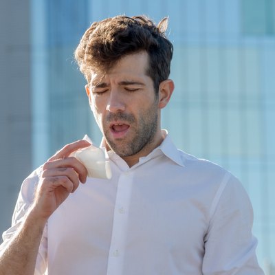 Young man with handkerchief about to sneeze