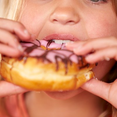 Close Up Of Girl Eating Iced Donut