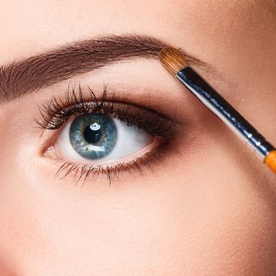 Beautiful female eyes with make-up and brush