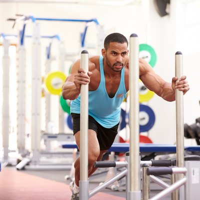 Muscular man working out using equipment at a gym