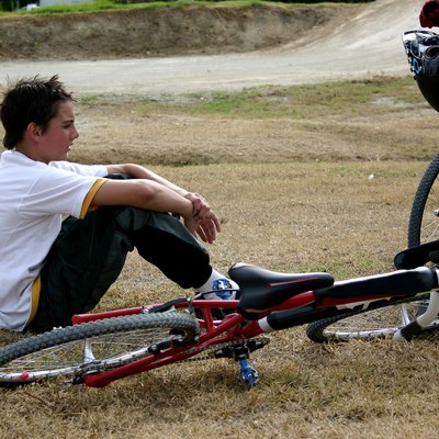 Boy sitting next to bmx bike