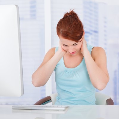 Businesswoman Suffering From Neckache At Computer Desk