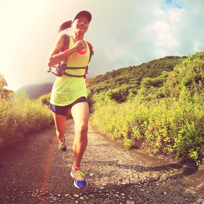 young fitness woman runner running on mountain trail