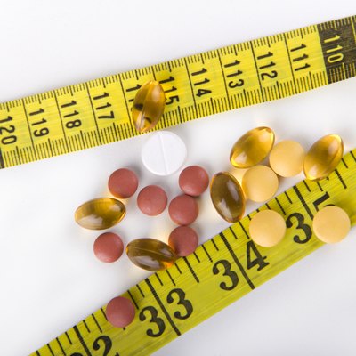 Diet Pills with yellow measuring tape