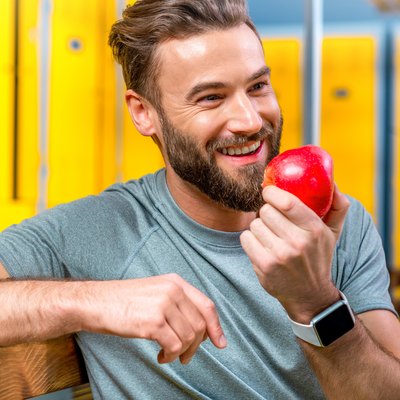 Man with apple in the gym