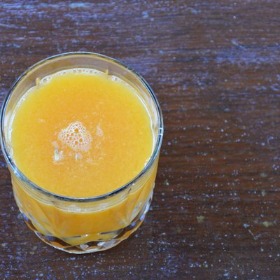 glass of orange juice on wooden table