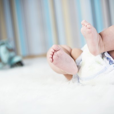 Newborn baby in diaper lying on plush blanket