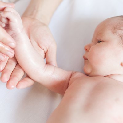 Mother makes massage for happy baby