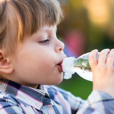 Portrait of little girl drinking water outdoor