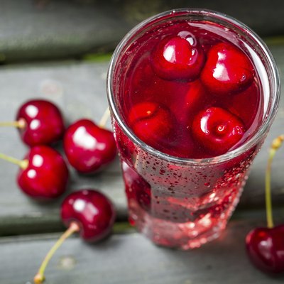 Closeup of fresh juice with sweet cherries and ice