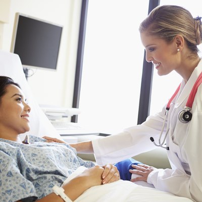 Doctor Talking To Female Patient On Ward