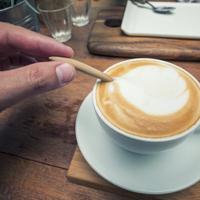 Close up hand mixing with a spoon of coffee.