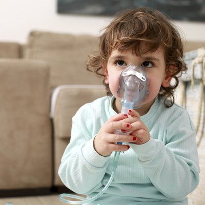 Portrait of a little girl with inhaling mask
