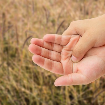 Close up hand pain with grass blurred background