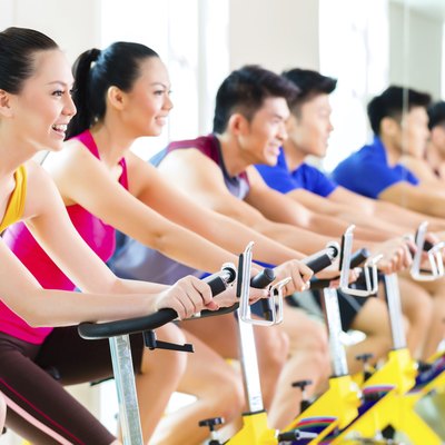 Asian people spinning bike training at fitness gym
