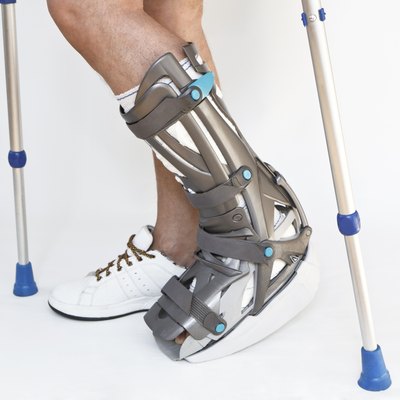 Man with a broken leg walking on crutches