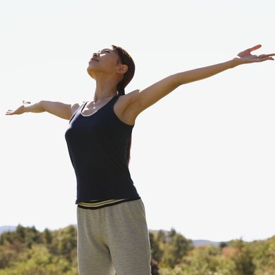 Young woman standing with arms outstretched, low angle