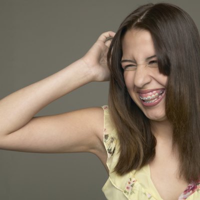 Young woman scratching her head and laughing