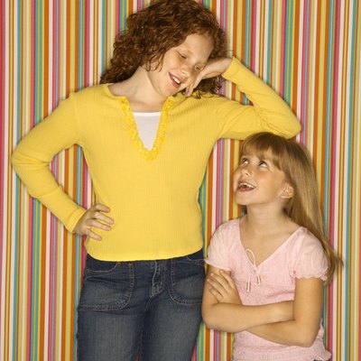 Girl leaning on smaller girl.