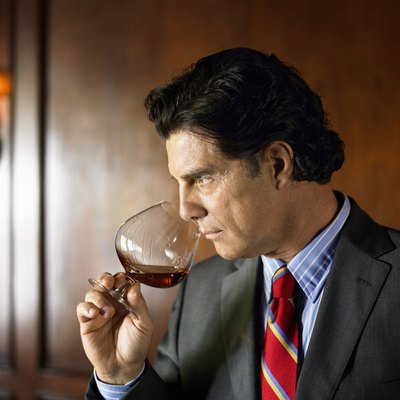 Mature man sniffing brandy from snifter