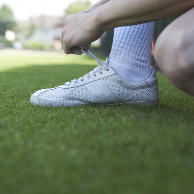 Male tennis player tying his shoe