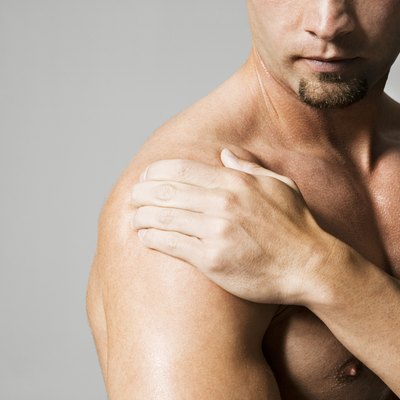 Man massaging shoulder, mid section