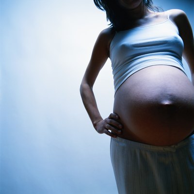 Pregnant woman with hand on hip, mid section
