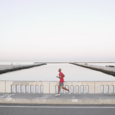 African American male runner on bridge
