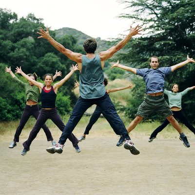 Man leading group of people in boot camp exercises, rear view