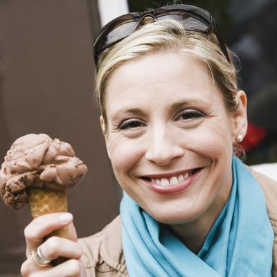 Woman holding an ice-cream cone and smiling