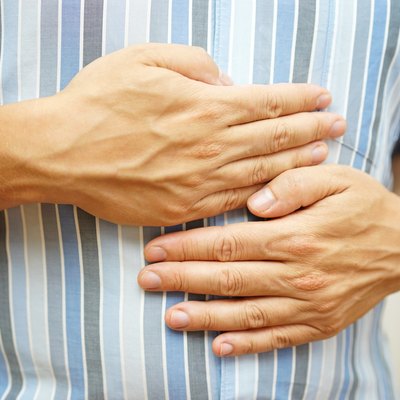 Stomach ache, man placing hands on the stomach, concept of .stomach ulcer