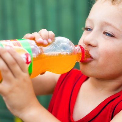Boy drinking unhealthy bottled soda