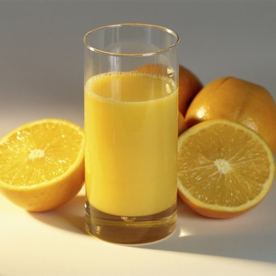 Glass of orange juice and oranges