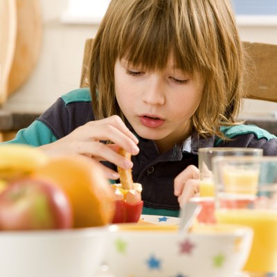Boy dipping a piece of toast into a boiled egg