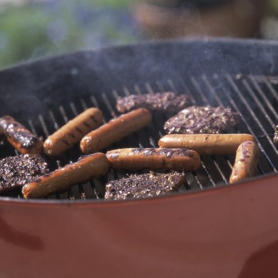 Close-up of hamburgers and hot dogs cooking on a barbecue grill
